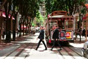 person passing through road beside tram