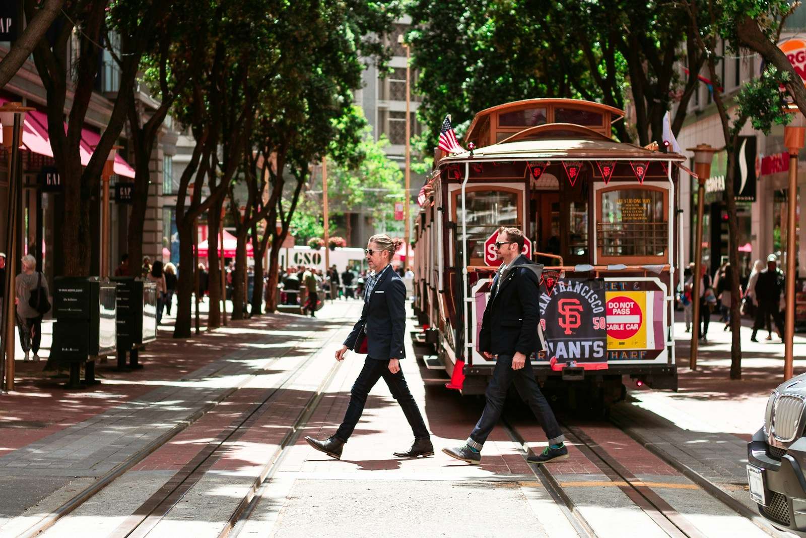 person passing through road beside tram